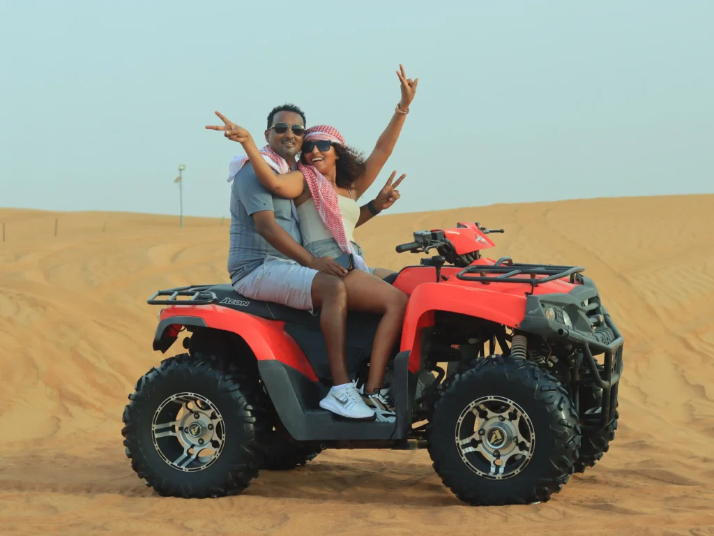 A couple riding squad bike in a desert in dubai